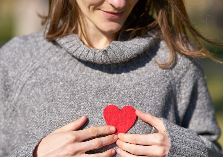 Et rødt hjerte på brystet af en kvinde. Foto: Pexels.com